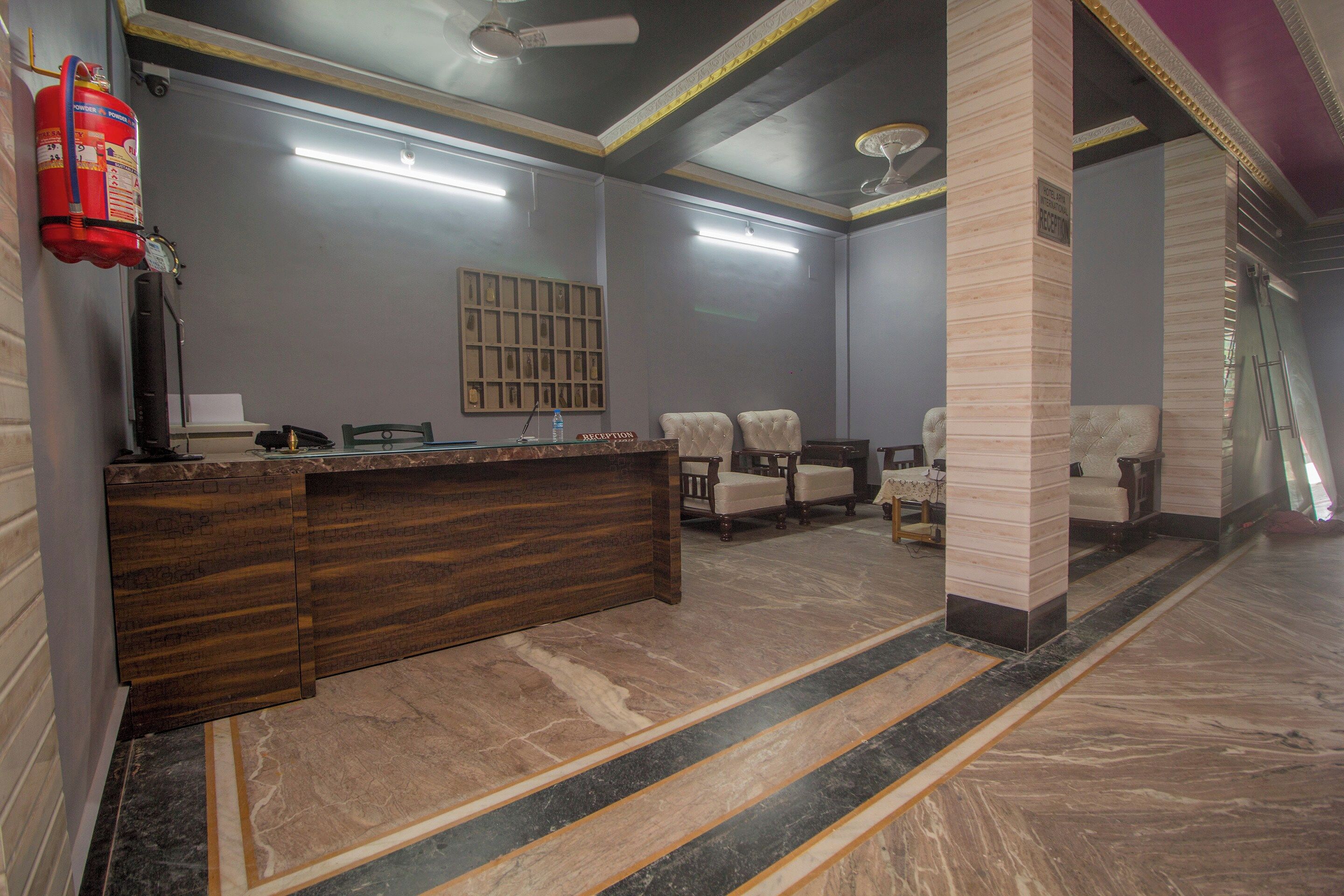 A reception area with a marble floor, a reception desk, and a fire extinguisher.