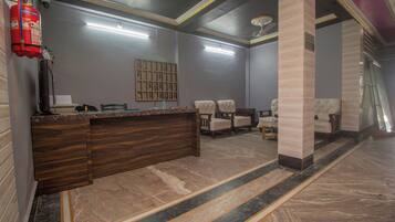 A reception area with a marble floor, a reception desk, and a fire extinguisher.