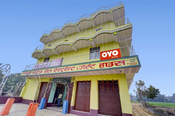 A multi-story building with balconies and a sign for 'OYO Rooms'.
