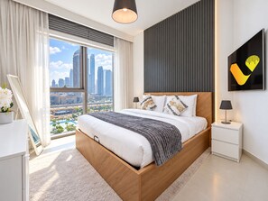 Een moderne slaapkamer met een groot bed, uitzicht over de stad en een minimalistische inrichting.