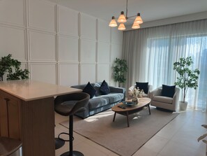 A modern living room with a sofa, armchairs, a coffee table, and a dining area. - Vogue | Downtown with Easy Access to Dubai Mall (Dubai)