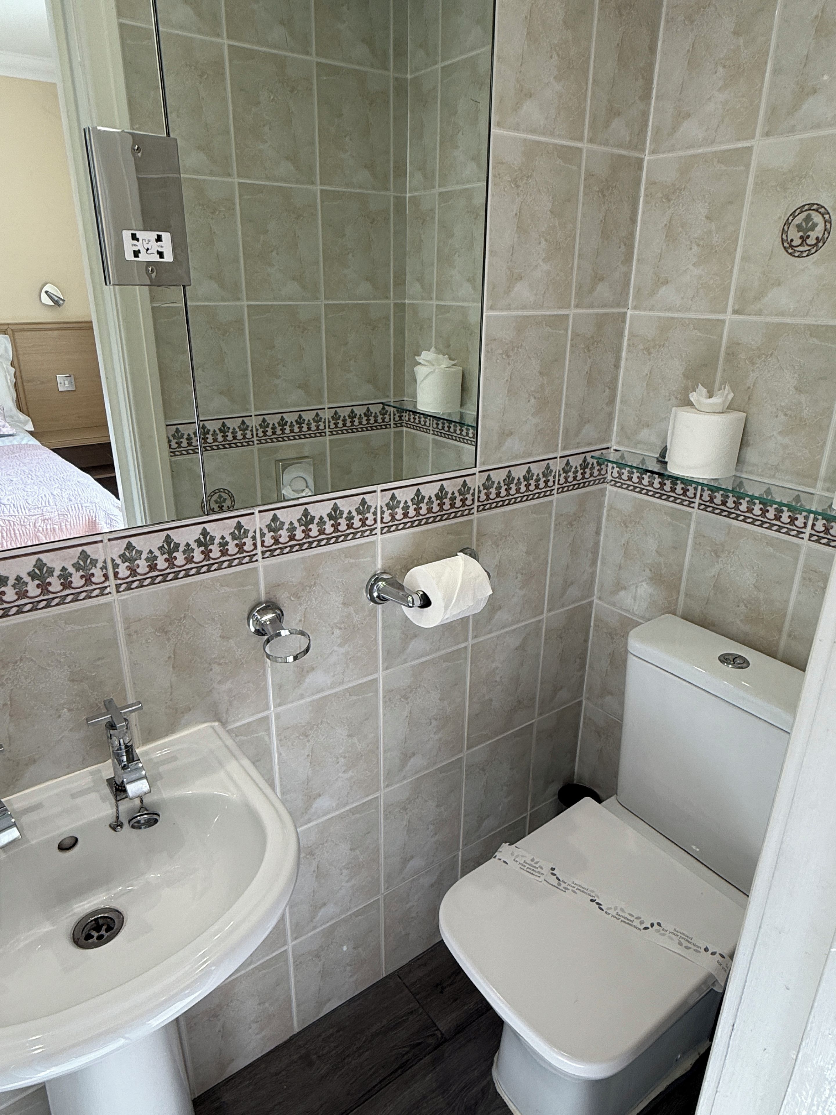 Ein Badezimmer mit Waschbecken, Toilette und Spiegel.