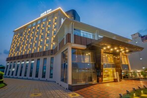 A modern hotel with a prominent entrance, multiple floors, and a well-lit facade. - Park Inn by Radisson Lucknow Vikas Nagar (Unnao)