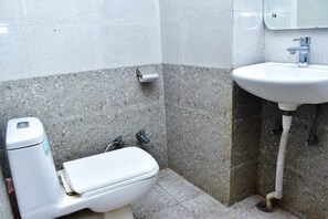 Un baño pequeño con inodoro, lavamanos y dispensador de toallas de papel.