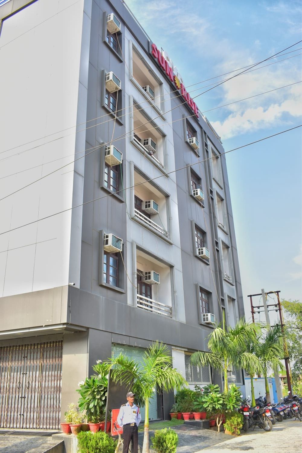 A multi-story building with balconies and air conditioning units.