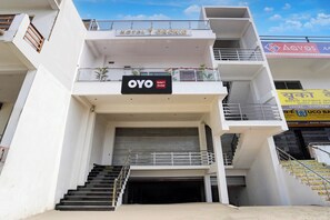 Un edifici de diversos pisos amb un distintiu cartell de 'OYO Hotel Orchid'.