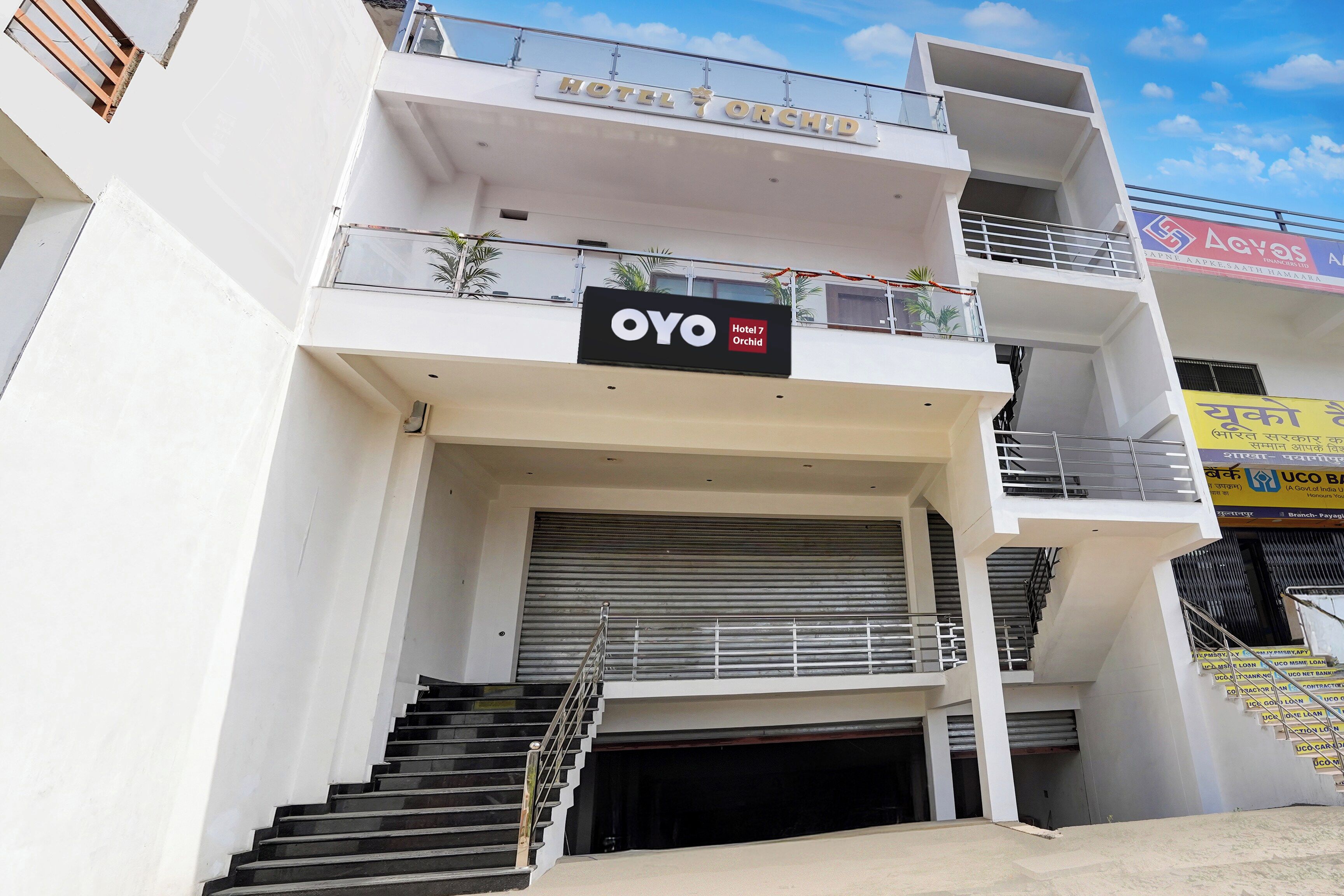 A multi-story building with a sign for 'OYO Hotel 7 Orchid' indicating a hotel establishment.