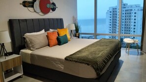 Una camera da letto moderna con un letto grande, vista su edifici alti e sullo skyline della città.