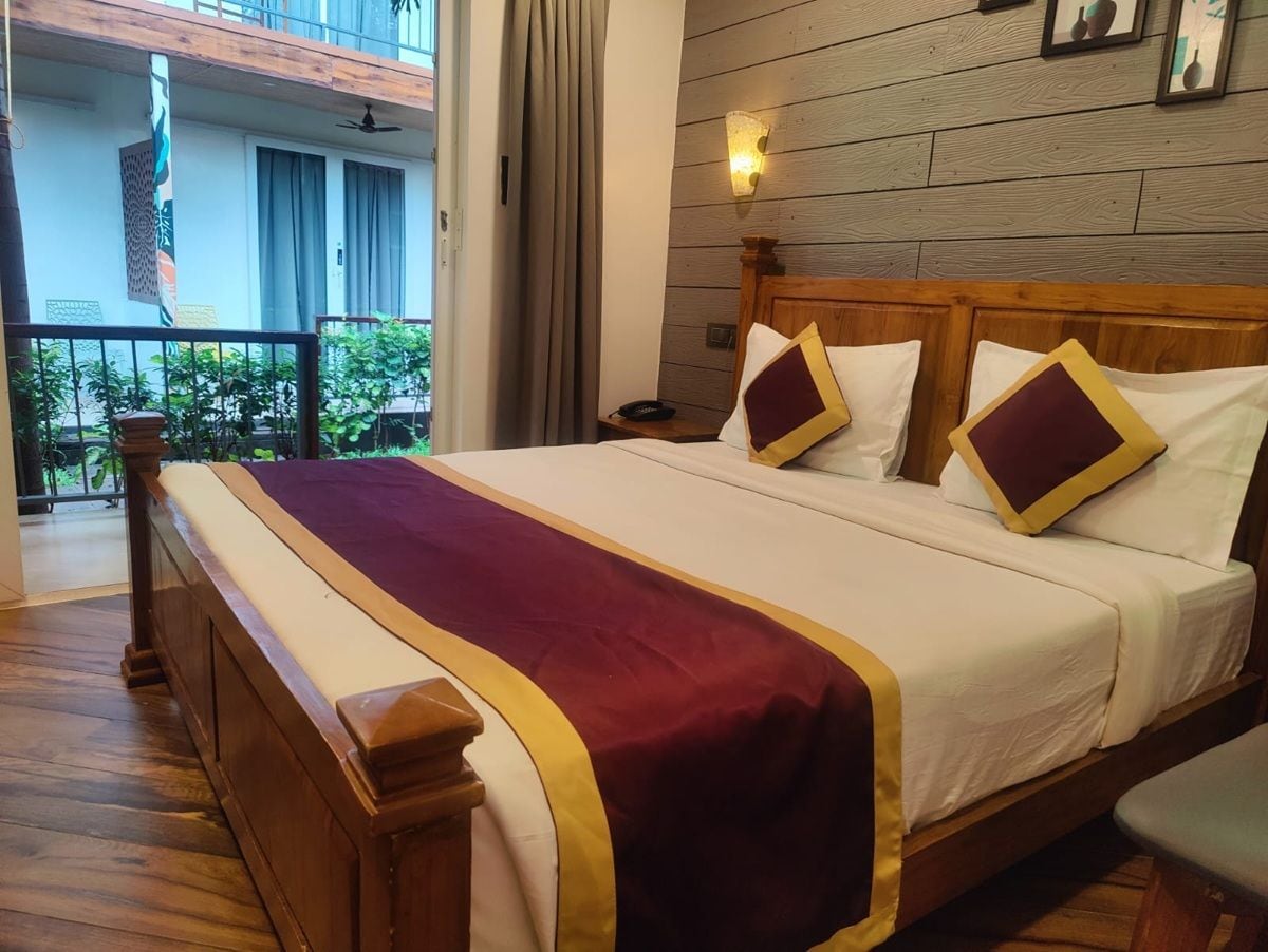 Ein Hotelzimmer mit einem Holzbett, einem Balkon mit Blick und einem Holzboden.