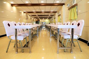 Une salle de conférence avec une longue table, des chaises et un plancher ciré.