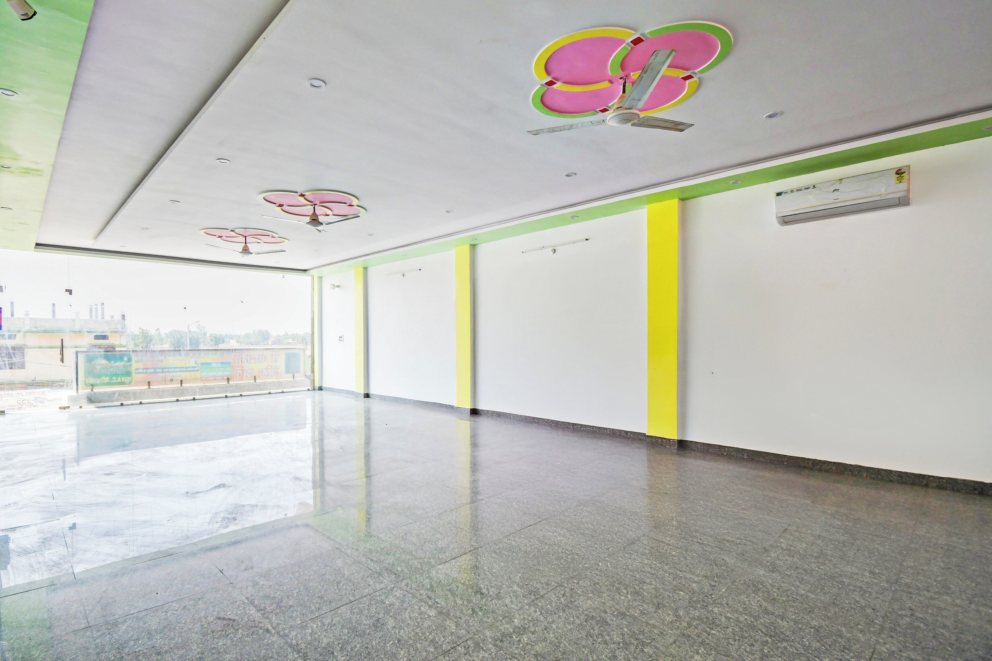 A corridor with a polished floor, white walls, and a green stripe.