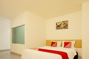 A hotel room with a bed, a window, and a painting on the wall. - Dancenter Hostel 77 Smart (Palembang)