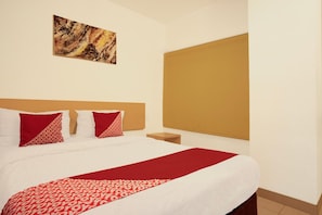 A hotel room with a bed, pillows, a nightstand, a painting, and a large window. - Dancenter Hostel 77 Smart (Palembang)