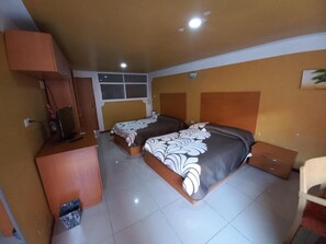 Une chambre avec deux lits, un bureau et une chaise.
