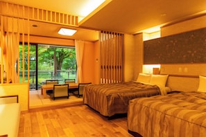 Een hotelkamer met balkon, bed, bureau en stoel.