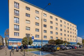 A multi-story building with a parking lot in front. - Warsaw | Staszica 4 | Bright Studio | Mezzanine (Warszawa)