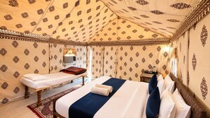 Una habitación con dos camas, una mesita con una tetera y paredes decoradas.