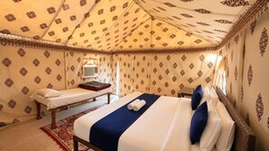 Una habitación con cama, un banco y un papel tapiz decorado.