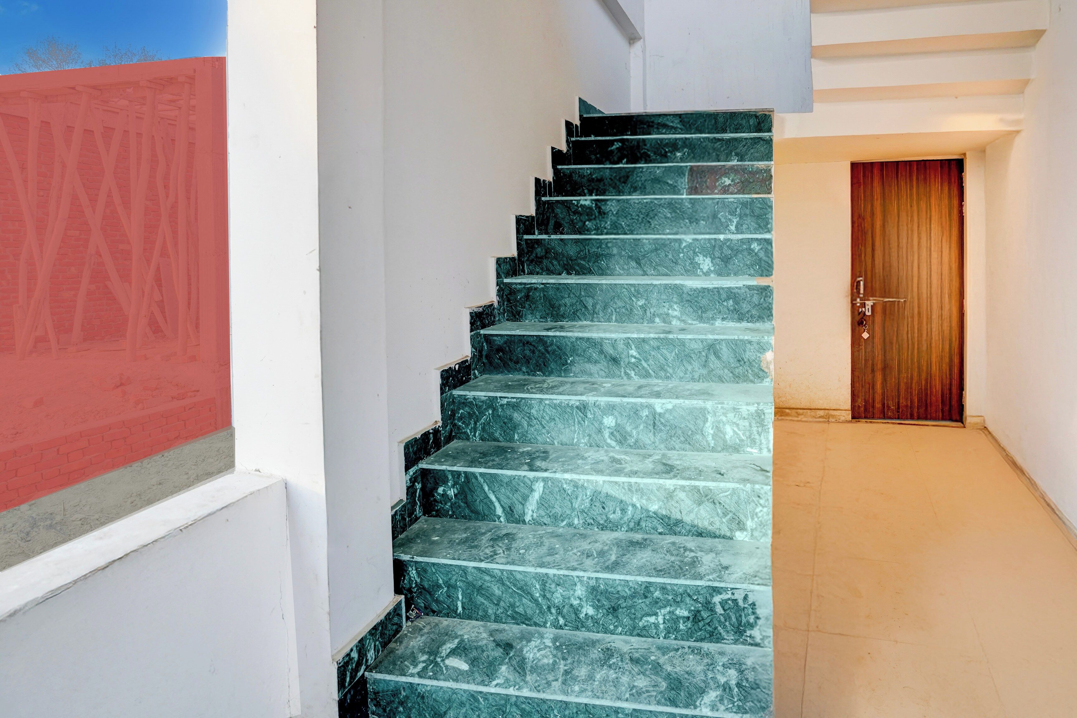 A staircase with a wooden door at the bottom.