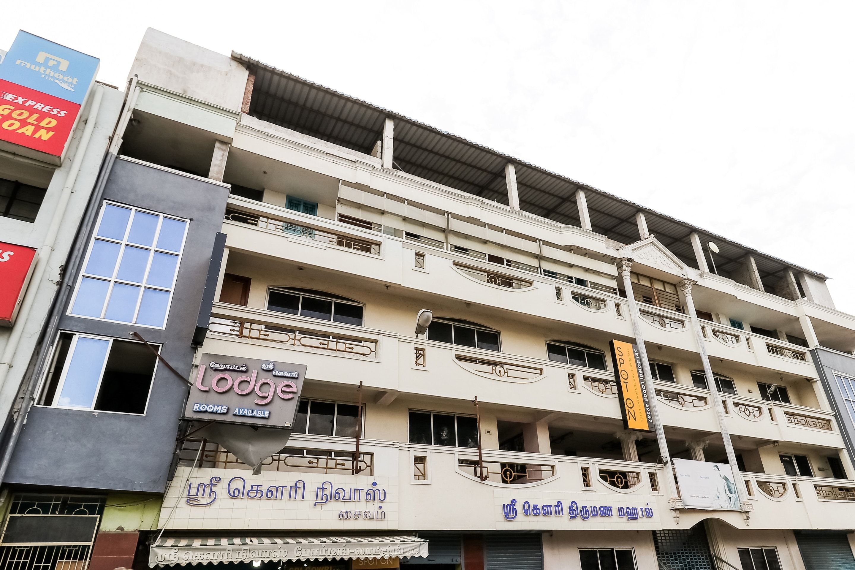 A multi-story building with commercial establishments on the ground floor, including a hotel named 'Lodge' and a restaurant.