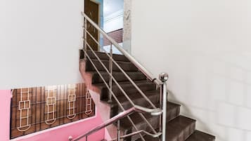 A staircase with metal railings and a pink wall.