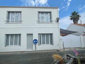Ein weißes Gebäude mit vielen Fenstern und einem blauen Hinweisschild.