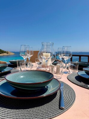 Una mesa dispuesta para comer con vista al mar.