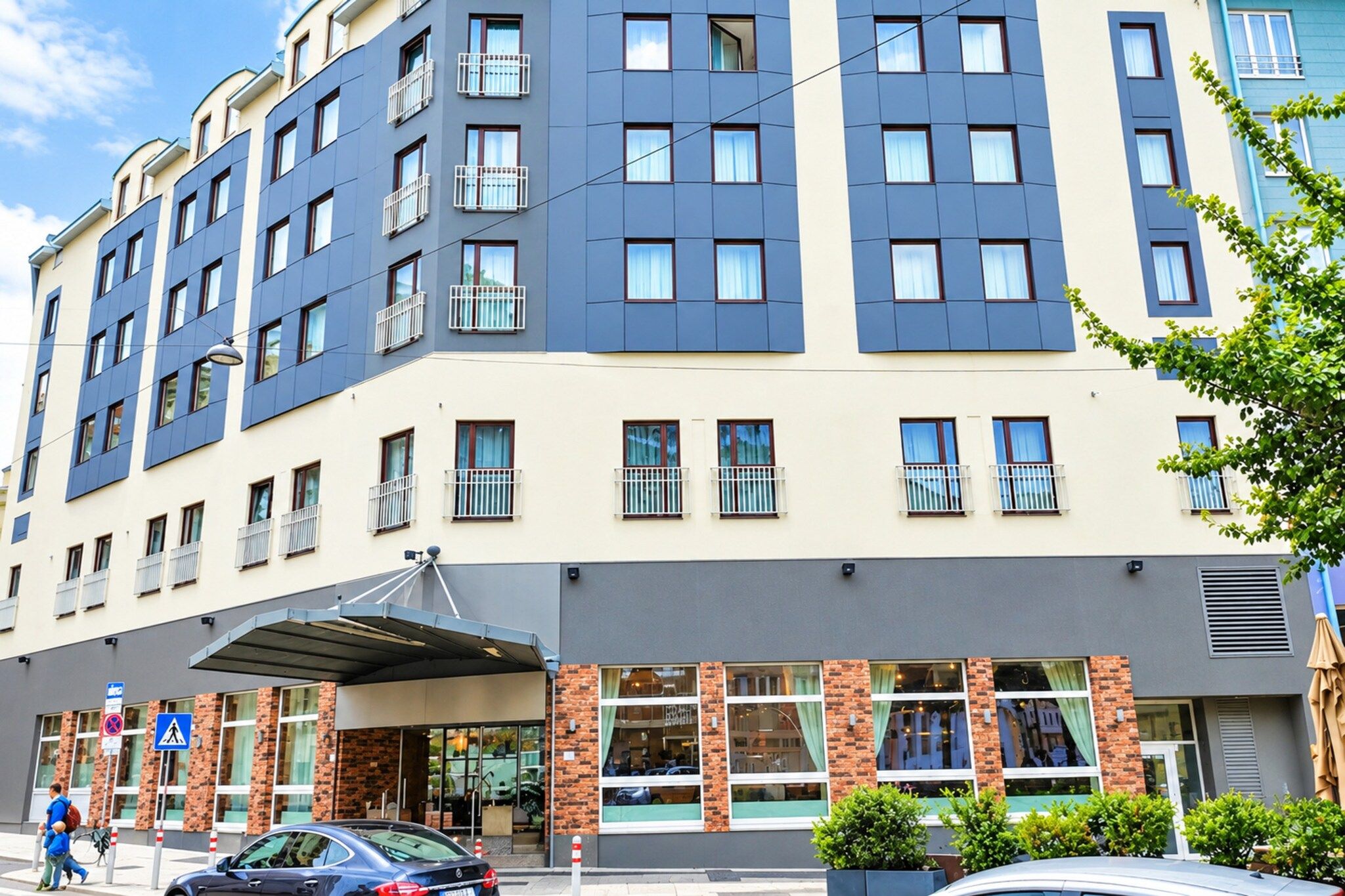 A multi-story hotel with a flat facade, large windows, and a covered entrance area.