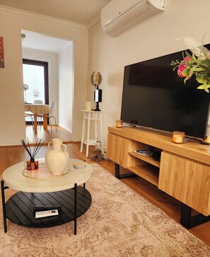 A living room with a TV, a small table with a vase, a lamp, and a plant. - Comfort & Central Location in Laverton (Laverton)