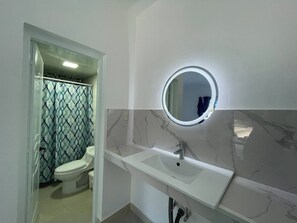 Ein Badezimmer mit Toilette, Waschbecken und Spiegel.
