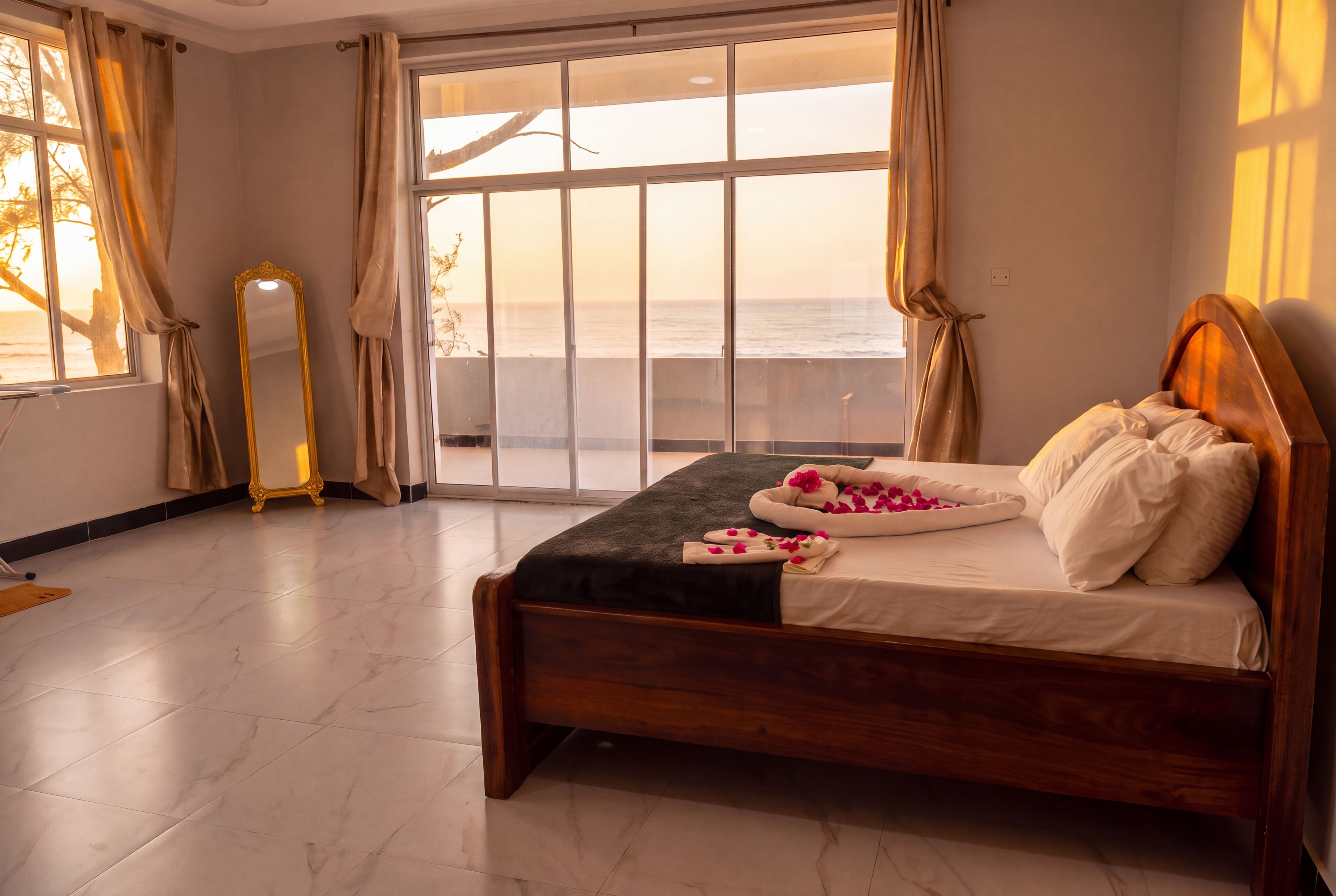 Une chambre à coucher avec un grand lit, un miroir et une vue sur la mer, accessible par une porte coulissante.