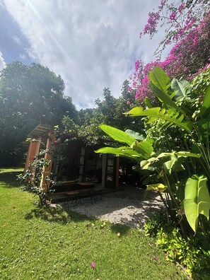 Ein Garten mit einem Pavillon, einem kleinen Gebäude und üppigem Grün.