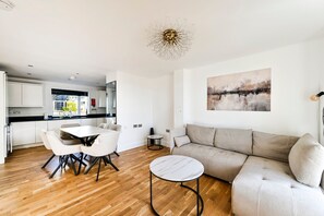 Een moderne woonruimte met een eethoek, een bank, een salontafel en een keuken op de achtergrond.