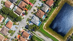 Vista aérea de una zona residencial con casas, una piscina y una gran masa de agua.