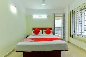 Ein Hotelzimmer mit einem Bett, einem Telefon und einem Fenster mit Jalousien.
