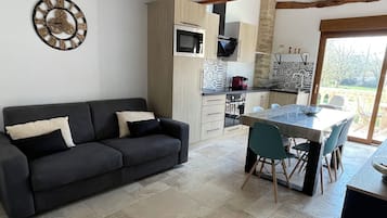 Een moderne keuken met een eethoek, een bank en uitzicht op de omgeving.