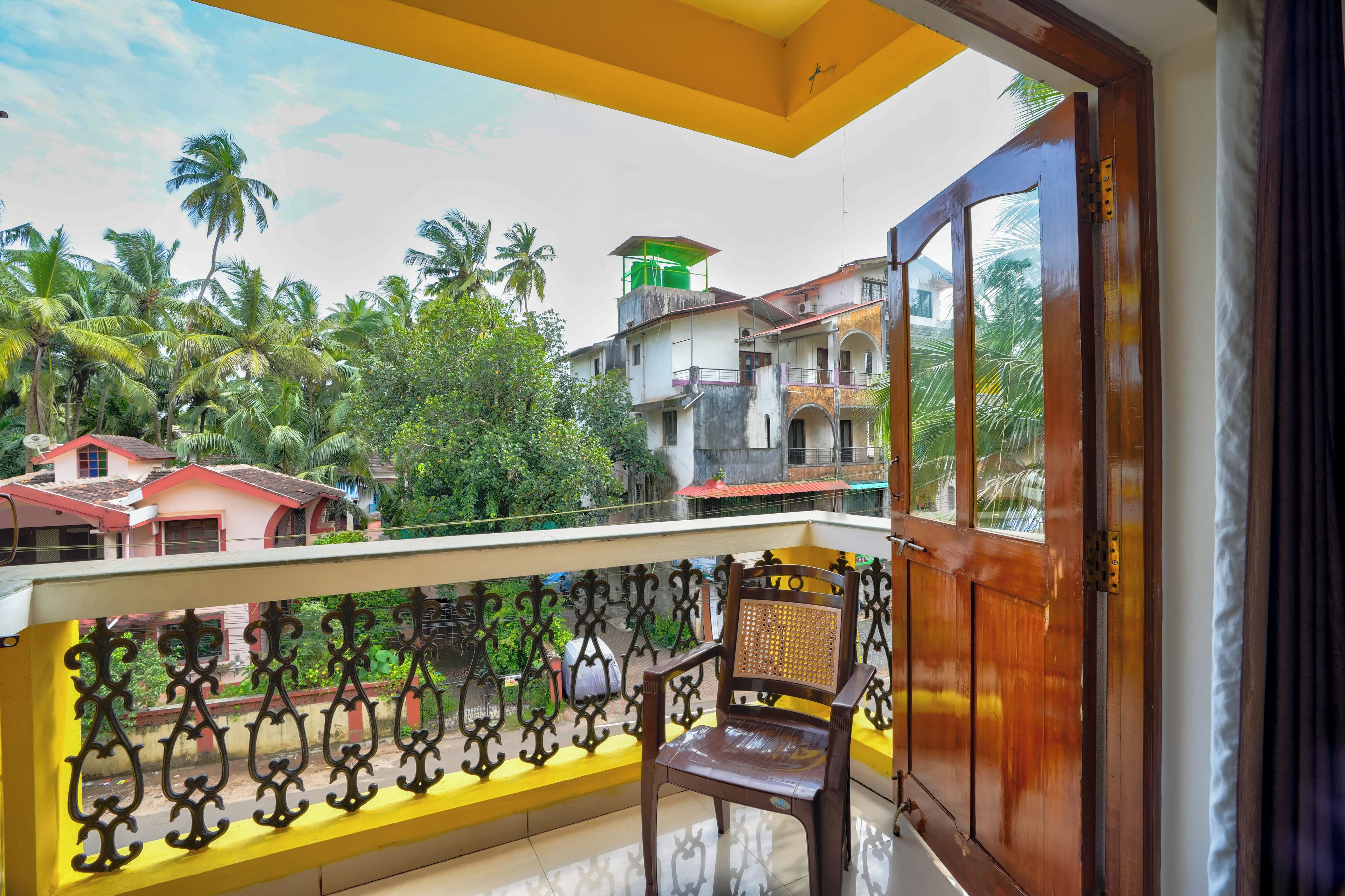 A balcony with a view of neighboring houses and palm trees.