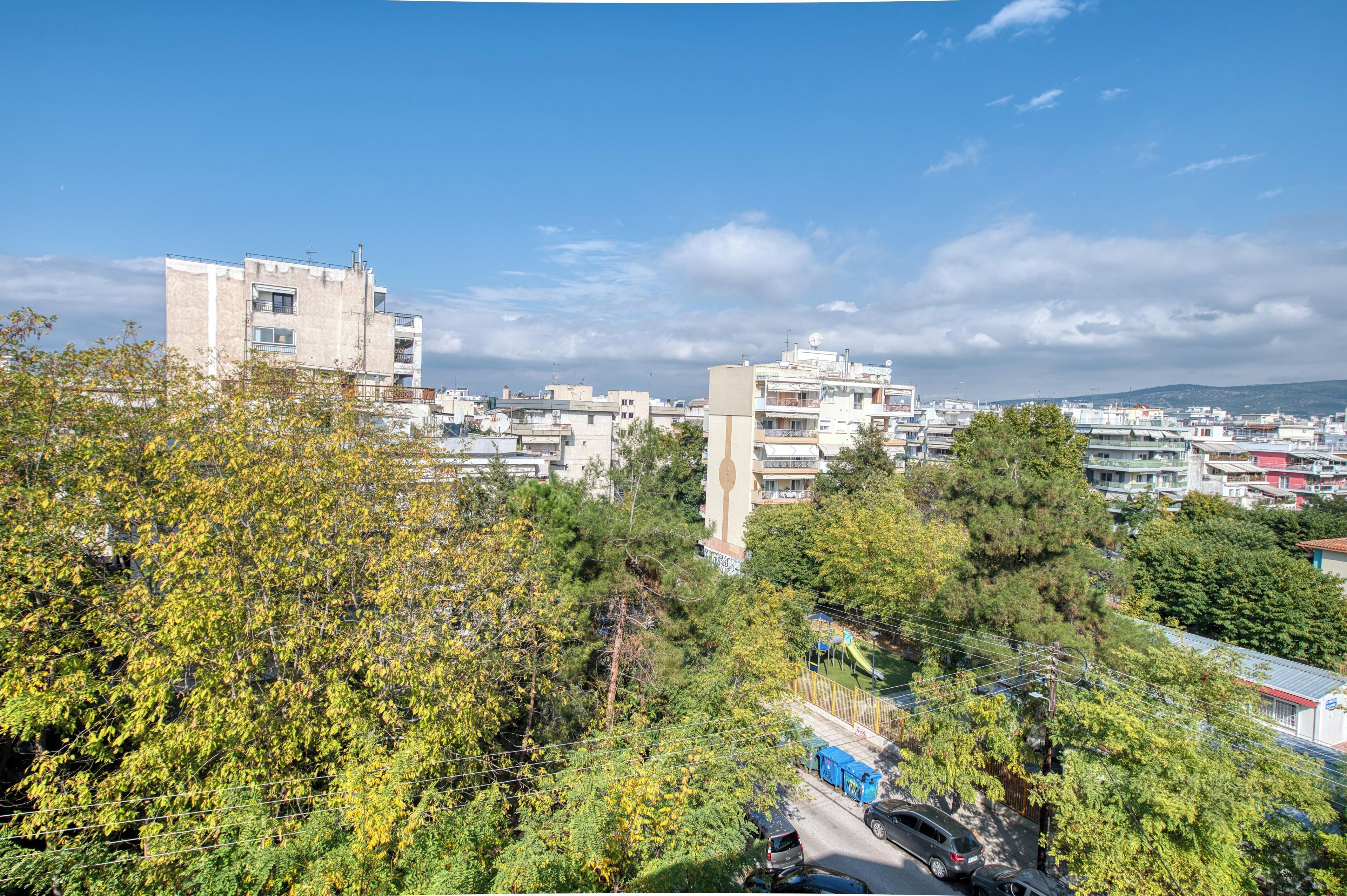 A cityscape with multiple buildings, trees, and a clear sky.
