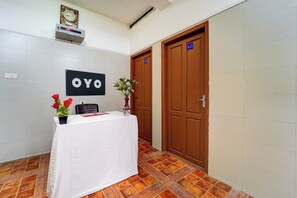 Een receptiegedeelte met een witte tafel, een klok en een bord waarop 'OYO' staat.