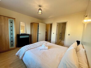 A bedroom with a bed, a wardrobe, a mirror, and a shower area. - Free Carpark Modern Lux 2 Bedroom Apt City Centre (Manchester)
