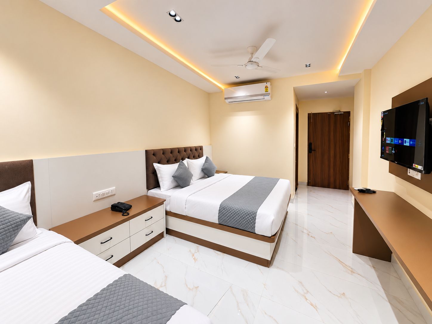 Habitación de hotel con cama, mesita de noche y televisor.