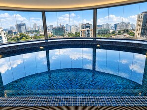 A circular infinity pool with a cityscape view through large windows. - Capital M Residences - LEED Certified (Nairobi)
