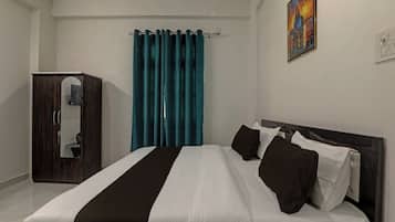 Une chambre d’hôtel avec un lit, une armoire, des rideaux de couleur turquoise et un tableau au mur.