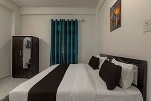 Une chambre d’hôtel avec un lit, une armoire, des rideaux de couleur turquoise et un tableau au mur.