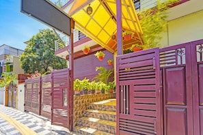 A gated entrance with a stone staircase leading to a covered porch area. - Hotel O Sivaganga Guest House (Trivandrum)