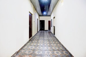 Un pasillo con piso estampado, puertas a ambos lados y un techo con diseño decorativo.