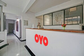 Ein Empfangsschalter mit einem Logo, eine Vase mit Blumen und ein Fenster mit Blick.