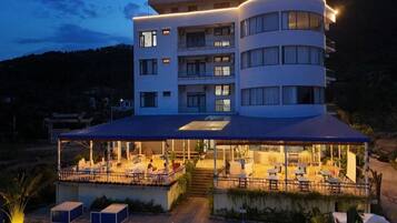 Un hotel de varios pisos con una zona de estar al aire libre cubierta.