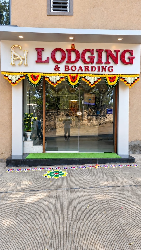 Un edificio con un letrero que indica 'Lodging & Boarding' y una zona de recepción.
