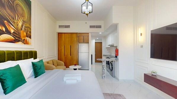 Une chambre d’hôtel comprenant un lit, un canapé, un coin repas et une télévision.